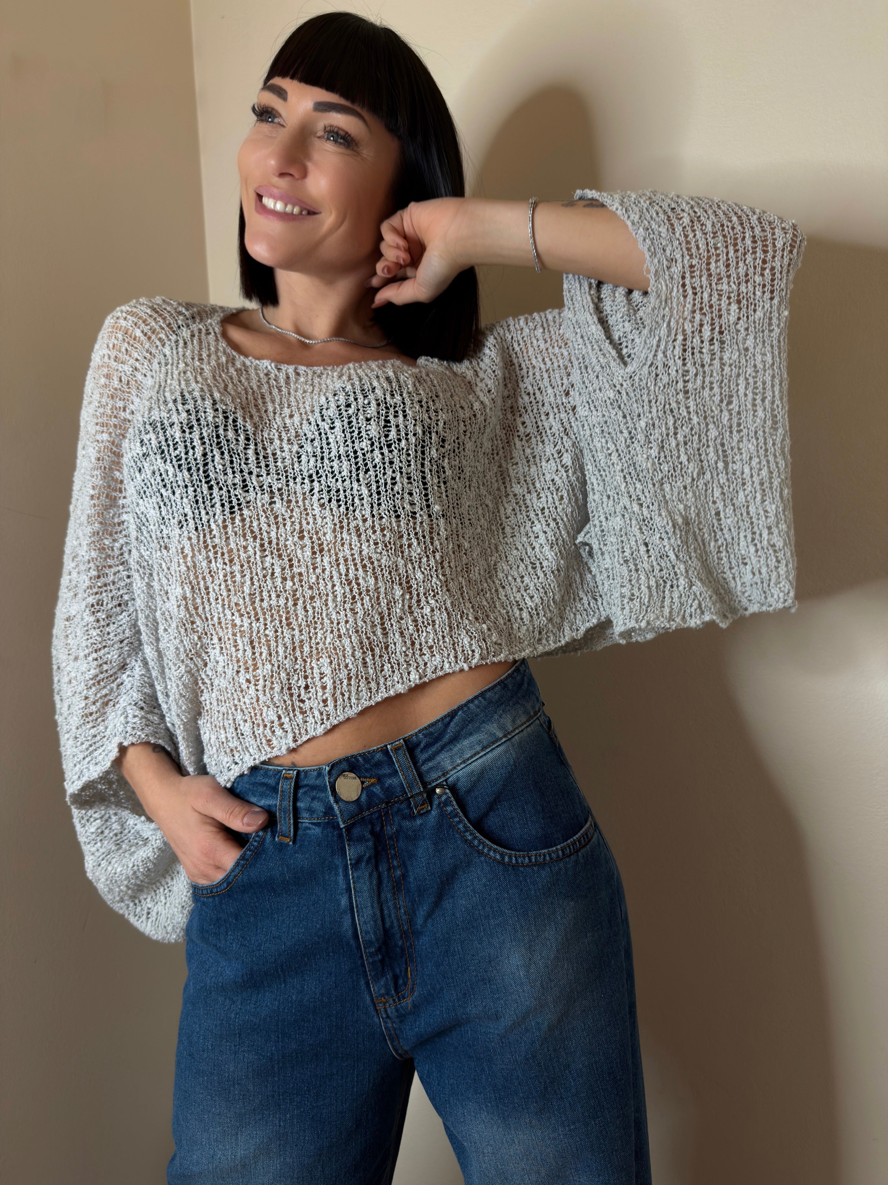 MAGLIA TRAFORATA CON MANICHE ASIMMETRICHE